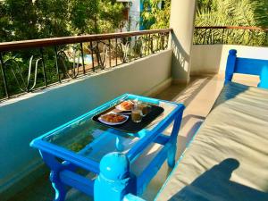 una bandeja de comida en una mesa en un balcón en Villa Elkoumy Apartments en Luxor