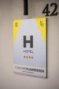 un cartel para un hotel en una pared en U Eat & Sleep Antwerp, en Amberes