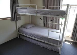 a room with two bunk beds and a ladder at 3 Bedrooms, 2 Toilets, 3 Car parking in Big Entire house Close to Makuhari Messe, Disneyland, airport and Tokyo for 12 guests in Kuguta