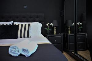 アテネにあるNeo Luxury Suiteのベッドルーム1室(黒いヘッドボード付きのベッド1台付)