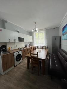 - une cuisine avec une table et un canapé dans une chambre dans l'établissement Hostel64, à Almaty