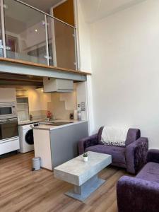sala de estar con 2 sillas de color púrpura y mesa en City Centre 2 Bed Duplex Flat en Nottingham