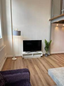 a living room with a flat screen tv on a table at City Centre 2 Bed Duplex Flat in Nottingham