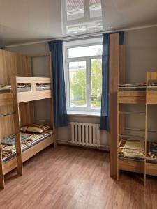 Cette chambre comprend 3 lits superposés et une fenêtre. dans l'établissement Hostel64, à Almaty