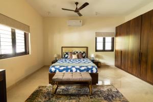 a bedroom with a bed and a ceiling fan at Luho 125 in Bangalore