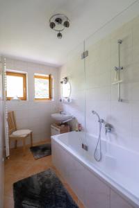 La salle de bains est pourvue d'une baignoire, d'une douche et d'un lavabo. dans l'établissement Ferienwohnung Falltannach, à Sonthofen