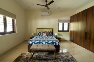 a bedroom with a bed and a ceiling fan at Luho 125 in Bangalore