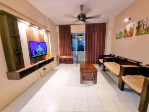 a living room with a couch and a tv at Kinora Homestay in Perai