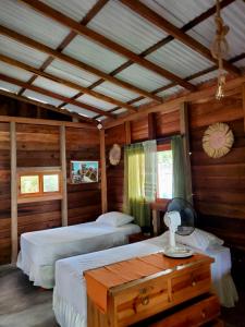sypialnia z 2 łóżkami i drewnianym sufitem w obiekcie La posada de Mary w mieście Montañita