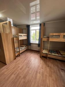 Cette chambre comprend plusieurs lits superposés et une fenêtre. dans l'établissement Hostel64, à Almaty