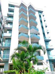 a tall building with a palm tree in front of it at Acogedor departamento junto al mar - Tonsupa in Tonsupa