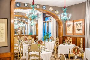 une salle à manger avec des tables blanches et des lustres dans l'établissement Hotel Duran, à Figueres