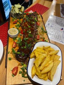 a table with a plate of food and a plate of fries at Dom Na Wodzie in Węgorzewo +8 photos