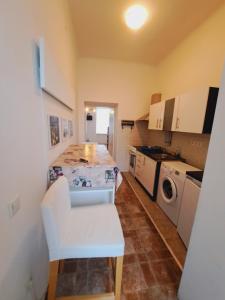 een kleine keuken met een tafel en een witte stoel bij Relax Appartement 10 minutes to downtown in Wenen