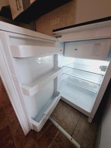 een lege koelkast met de deur open in een keuken bij Relax Appartement 10 minutes to downtown in Wenen