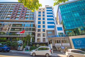 um carro branco estacionado em frente a edifícios altos em Sirius Otel İstanbul em Istambul