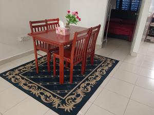 a dining room table with two chairs and a vase with flowers at Afna Homestay 2 in Kuala Lipis