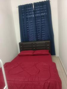 een slaapkamer met een bed met rode lakens en een raam bij Afna Homestay 2 in Kuala Lipis