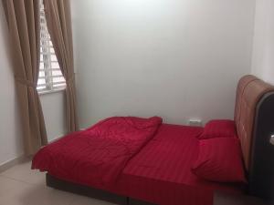 a red bed in a room with a window at Afna Homestay 2 in Kuala Lipis