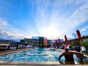 a man sitting in a swimming pool on a building at Banbua Grand Udon in Udon Thani