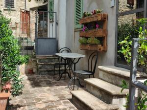 - une terrasse avec une table, des chaises et des fleurs dans l'établissement Casa Etrusca, à Città di Castello