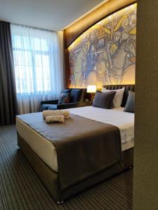 um quarto de hotel com uma cama grande com um quadro na parede em Orienta Hotel Gyumri em Guiumri