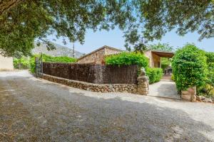 uma casa com uma parede de pedra e uma cerca em Navarro em Pollença