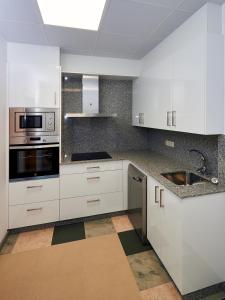 a kitchen with white cabinets and stainless steel appliances at Casa Río Samo in Garabanja +19 photos