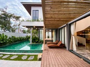 - une vue extérieure sur une maison avec une piscine dans l'établissement Song Cat Villa 59NL, à Đà Nẵng