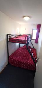 Cette petite chambre dispose de 2 lits superposés et d'une fenêtre. dans l'établissement Les Balcons du Soleil Appt303 à100m pistes 2 chambres parking couvert WIFI, à Orcières