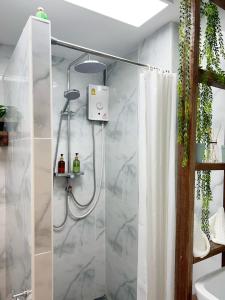 a shower with a white shower curtain in a bathroom at Cozy chic Silom townhouse studio 2-4 in Bangkok