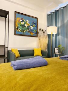 a bedroom with a yellow bed and a couch at Cozy chic Silom townhouse studio 2-4 in Bangkok