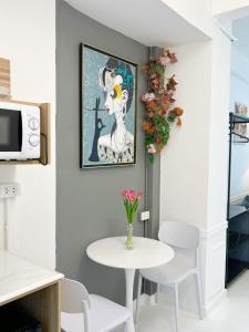 a dining room with a table and a vase of flowers at Cozy chic Silom townhouse studio 2-4 in Bangkok