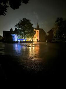 een donkere straat met een boom voor een gebouw bij Hôtel les Berges in Chippis