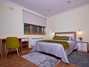 a bedroom with a bed and a desk and a chair at Casa Río Samo in Garabanja