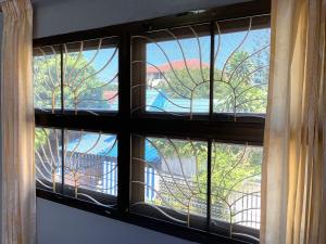a window with a view of a tree at Private room in Central Pattaya Naeem House in Nong Prue
