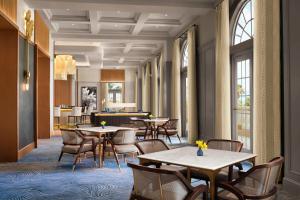 un comedor con mesas, sillas y ventanas en The Ritz-Carlton Naples en Naples