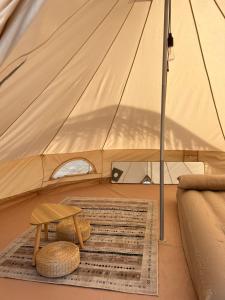 uma tenda com um banco, uma mesa e um tapete em Long Beach Camp em Ilhas Perhentian