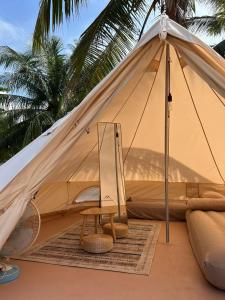 a tent with a table and a chair in it at Long Beach Camp in Perhentian Islands
