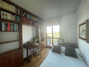 a bedroom with a bed and a desk and book shelves at Accomodo MIT37 Trivano Niguarda in Milan