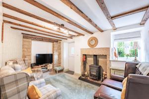 a living room with a fireplace and a tv at 1 Promenade View in Cromford