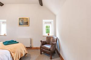een slaapkamer met een stoel naast een bed bij 1 Promenade View in Cromford