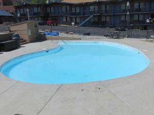 une grande piscine bleue dans un parking dans l'établissement Silver Saddle Motel, à Manitou Springs