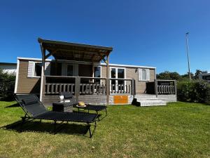 a house with a porch and a deck with a chair at De Strandhoed Renesse - Zee & Strand & Centrum in Renesse