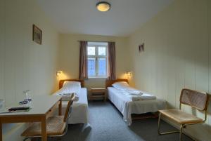 Ebsens Hotel في ماريبو: غرفة بسريرين وطاولة وكراسي