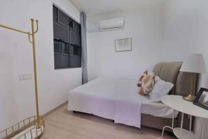 Dormitorio blanco con cama y mesa en 16 Forest City homestay-free WIFI-森林城市民宿, en Johor Bahru