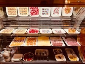 a display case filled with lots of different types of food at Avenue Hotel by F-Hotels in Blankenberge