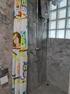 La salle de bains est pourvue d'une douche avec rideau de douche. dans l'établissement Juliet Home Samui, à Ban Lamai