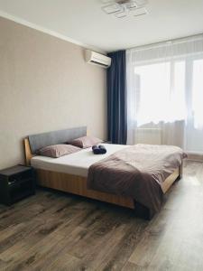 una camera con un letto e una grande finestra di 1-комнатная квартира a Pavlodar