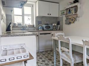 cocina con armarios blancos, mesa y sillas en Kleine Villa - ganzes Stadthäuschen für Gruppen Familien oder nur zu Zweit en Bamberg